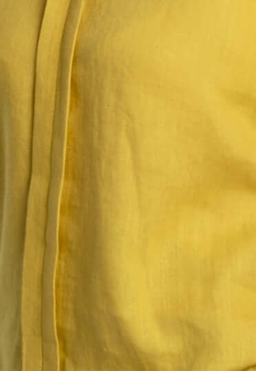 Close-up view of a yellow women's oversized long sleeve linen shirt, showcasing its lightweight, breathable fabric and elegant texture.