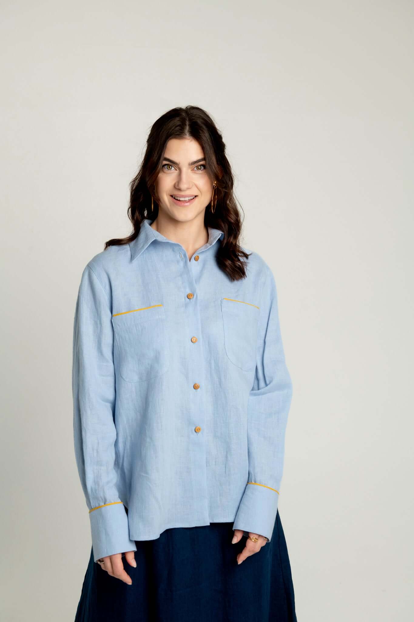 Oversized linen shirt with yellow details Brillante in light blue, showcasing comfort and style.
