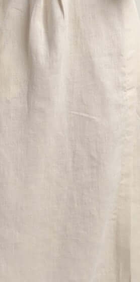 Close-up of a beige linen fabric, showcasing texture and breathability of women's linen waistcoat Vesta.