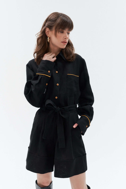 Woman wearing black wide-leg linen shorts Bonita paired with the Brillante long-sleeve oversized linen shirt with yellow accents, styled with ankle boots.