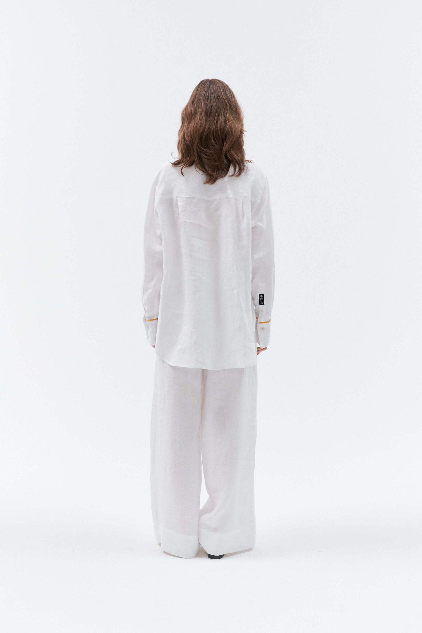 Back side of Grand Duchess women white oversized linen shirt with yellow details.