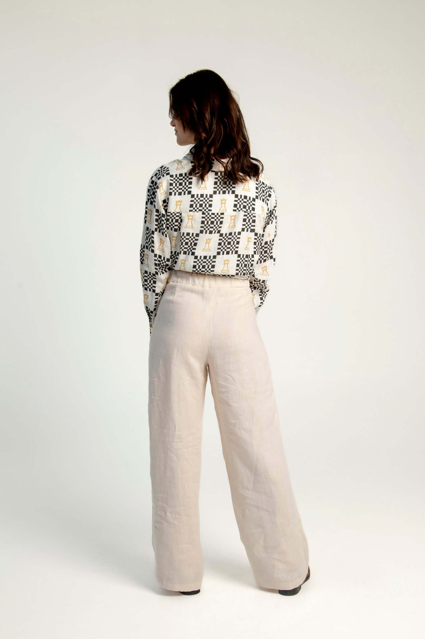 Women wearing high-waisted linen pants Independence II in beige, back view.