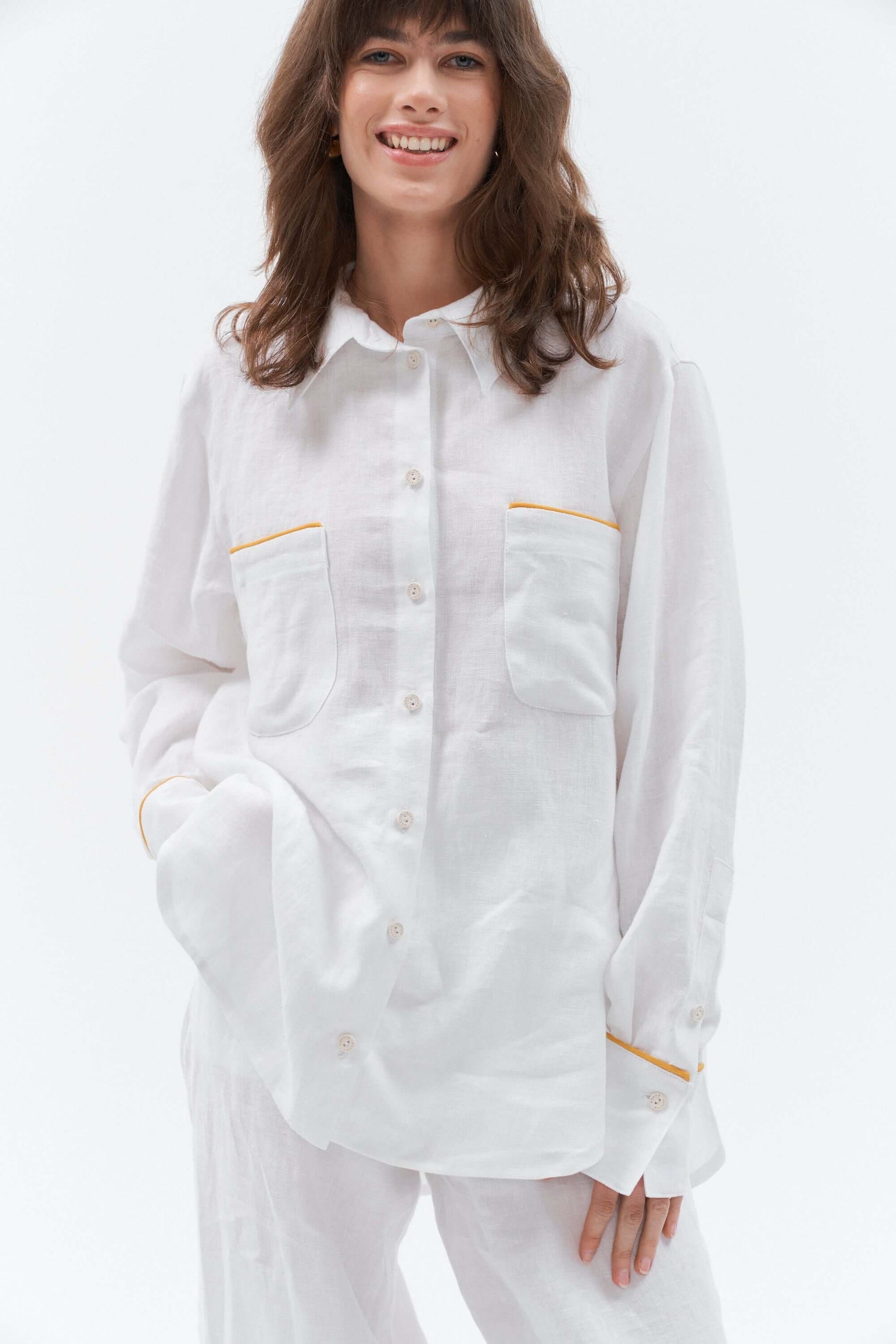 White oversized linen shirt with yellow details.