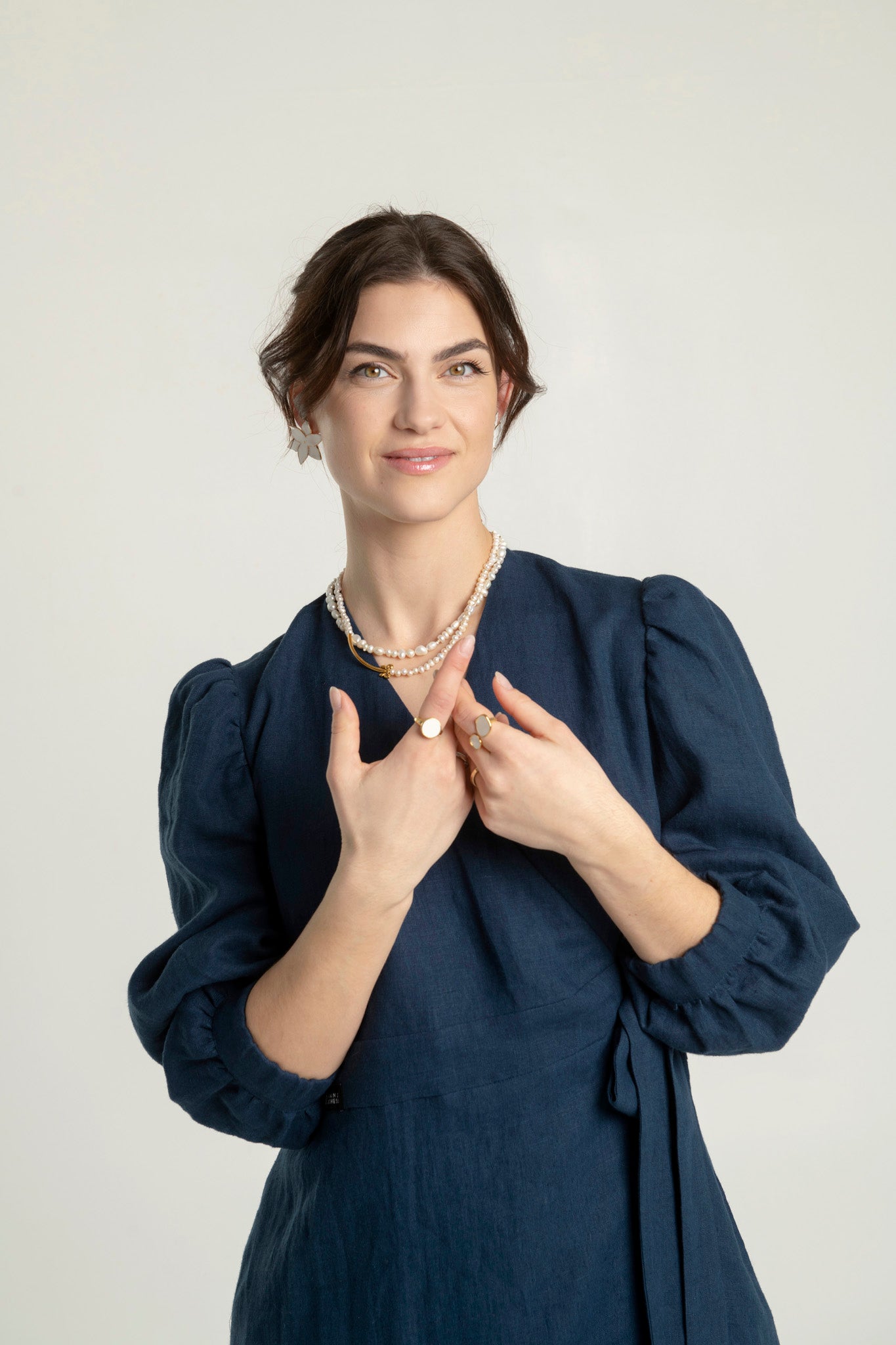 Crossover linen midi dress with pockets Riviera worn by a woman, showcasing elegant puff sleeves.