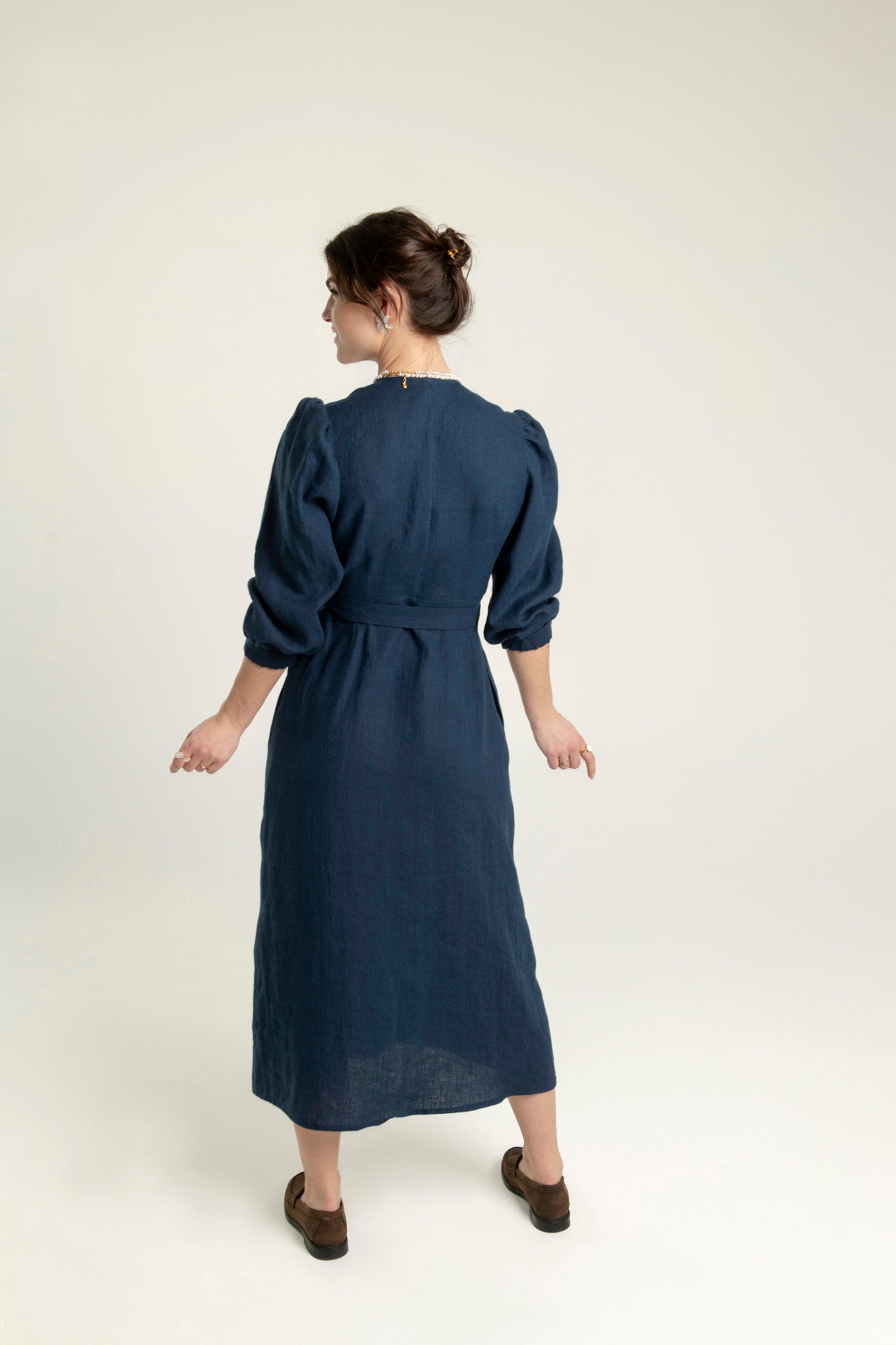 Crossover linen midi dress with pockets in navy, showing back view and elegant fit.