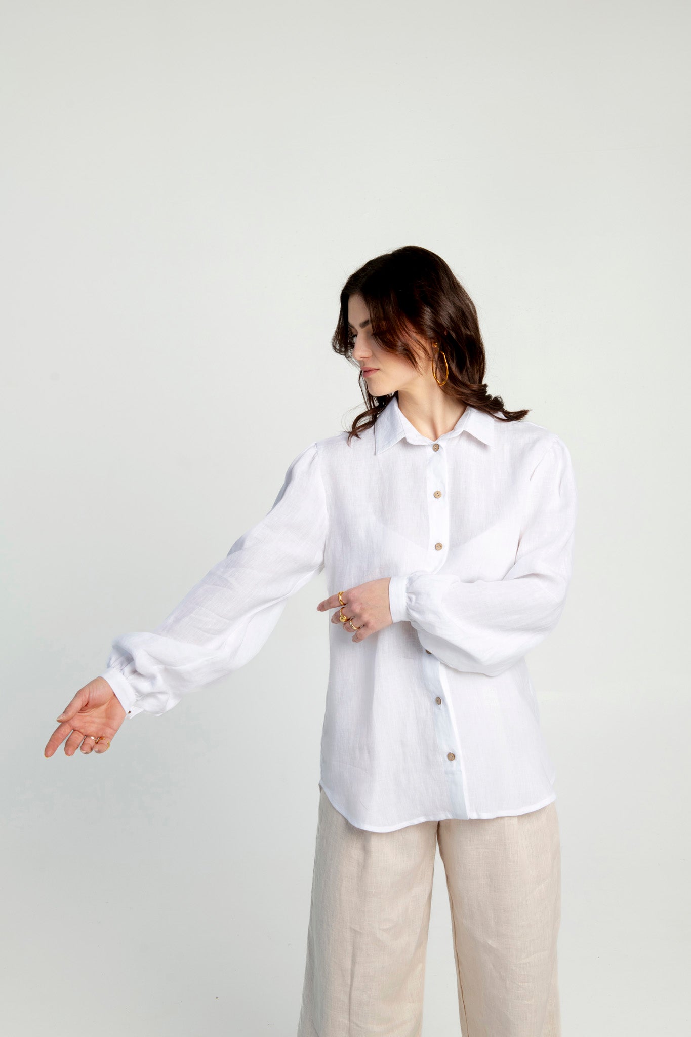 Linen shirt with puffed sleeves Astoria in white, featuring a relaxed fit and button details, modeled casually.